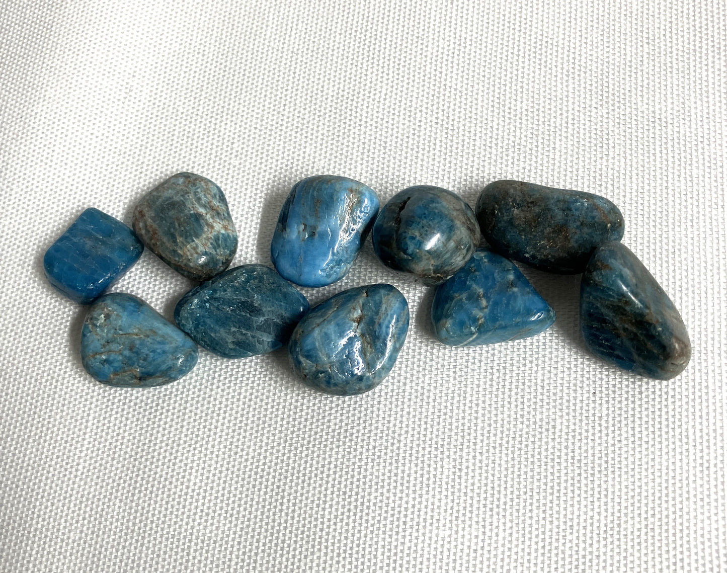 Group of Blue Apatite Crystals on a textured white surface