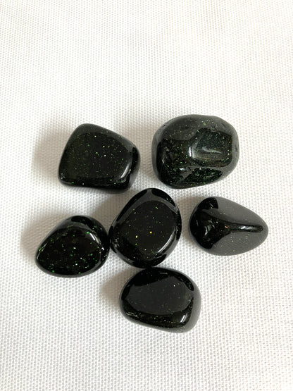 Tumbled Green Goldstone Crystals on a white background