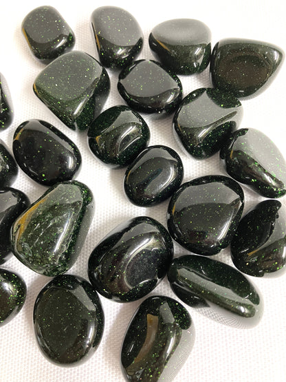 Group of Tumbled Green Goldstone Crystals showing different views on a white background