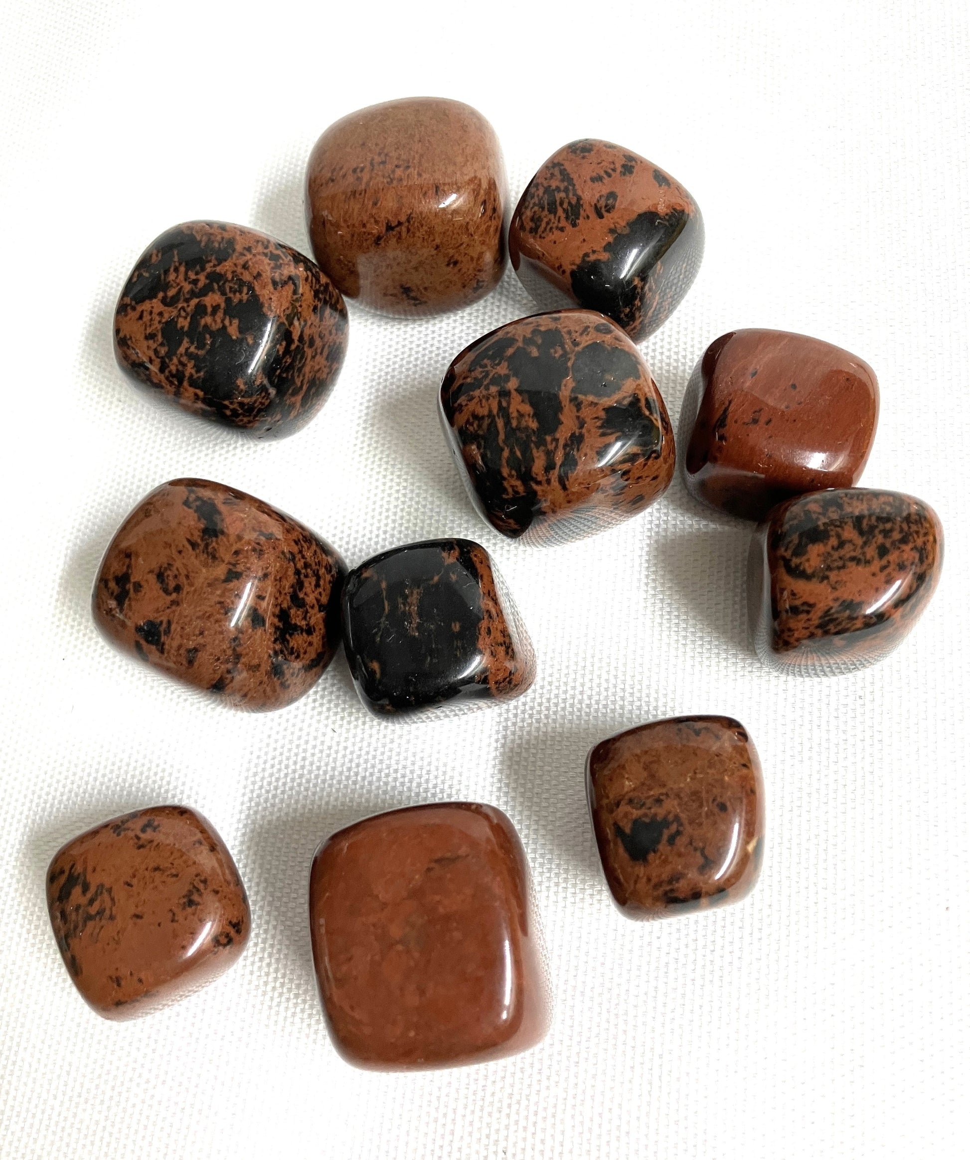 Back view of Mahogany Obsidian Crystals on a white fabric background