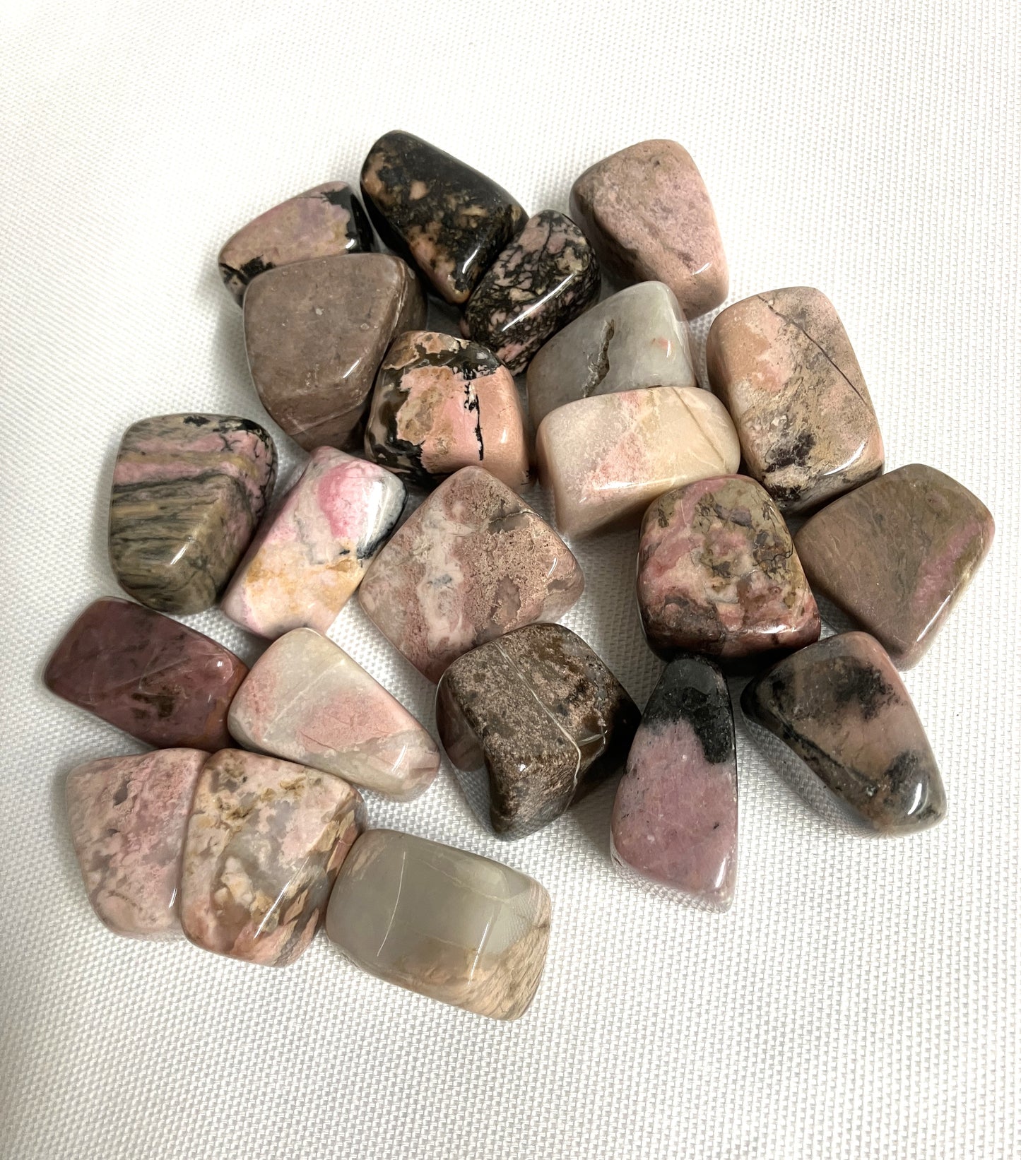 Bottom side of Rhodonite Crystals on a white fabric background