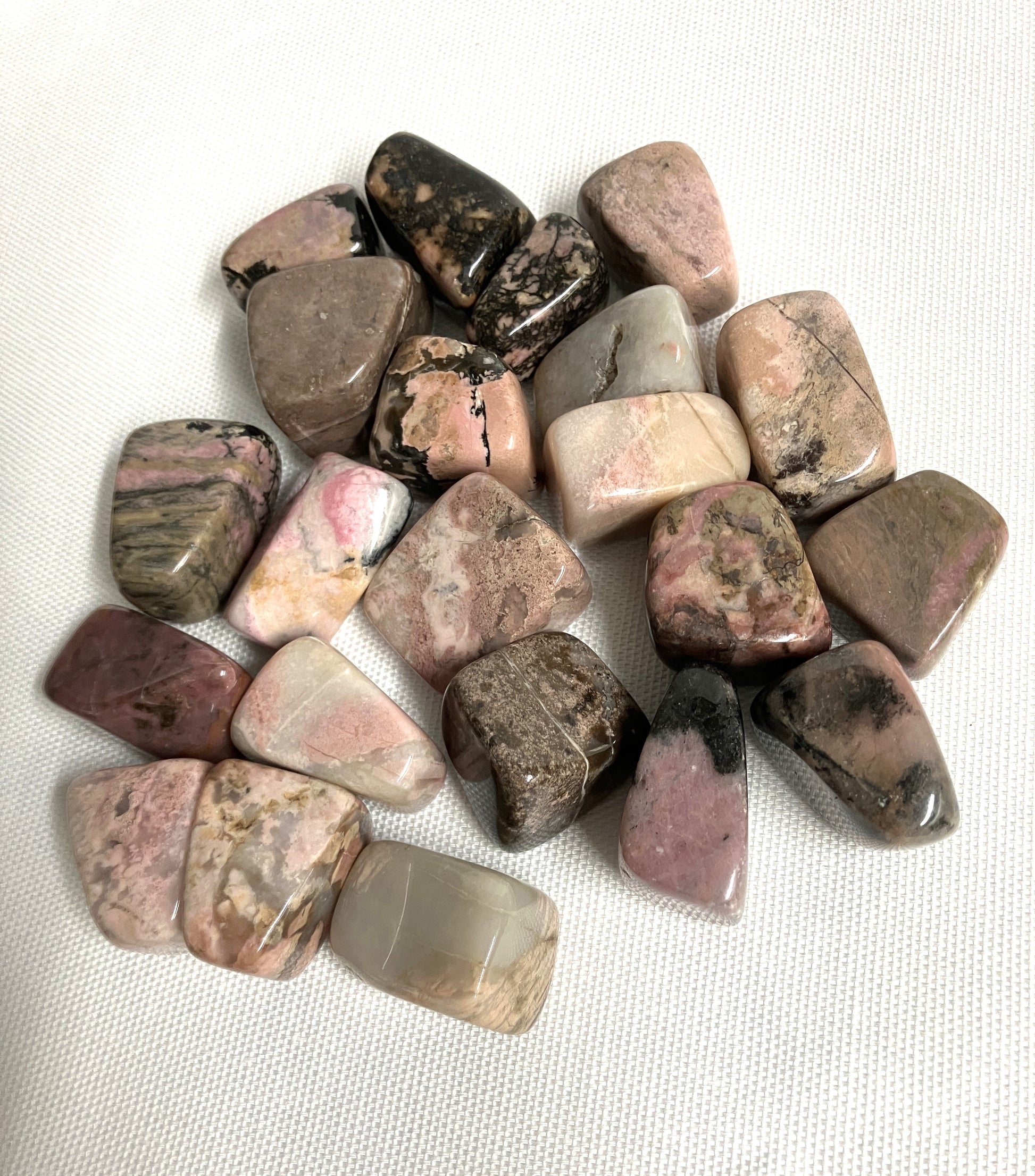 Bottom side of Rhodonite Crystals on a white fabric background