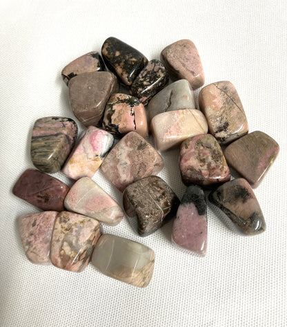 Bottom side of Rhodonite Crystals on a white fabric background
