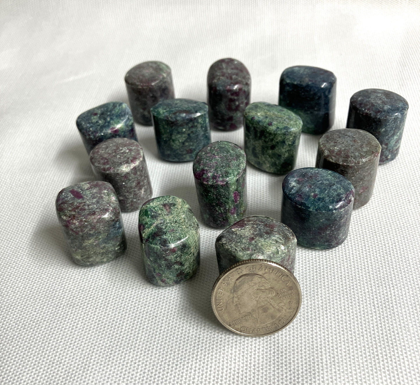 Ruby Kyanite Crystals with a quarter for scale on a white background