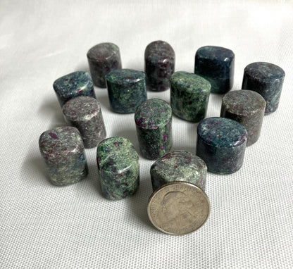 Ruby Kyanite Crystals with a quarter for scale on a white background