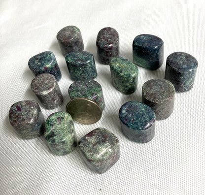 Group of Ruby Kyanite Crystals  with a quarter for scale on a white fabric background