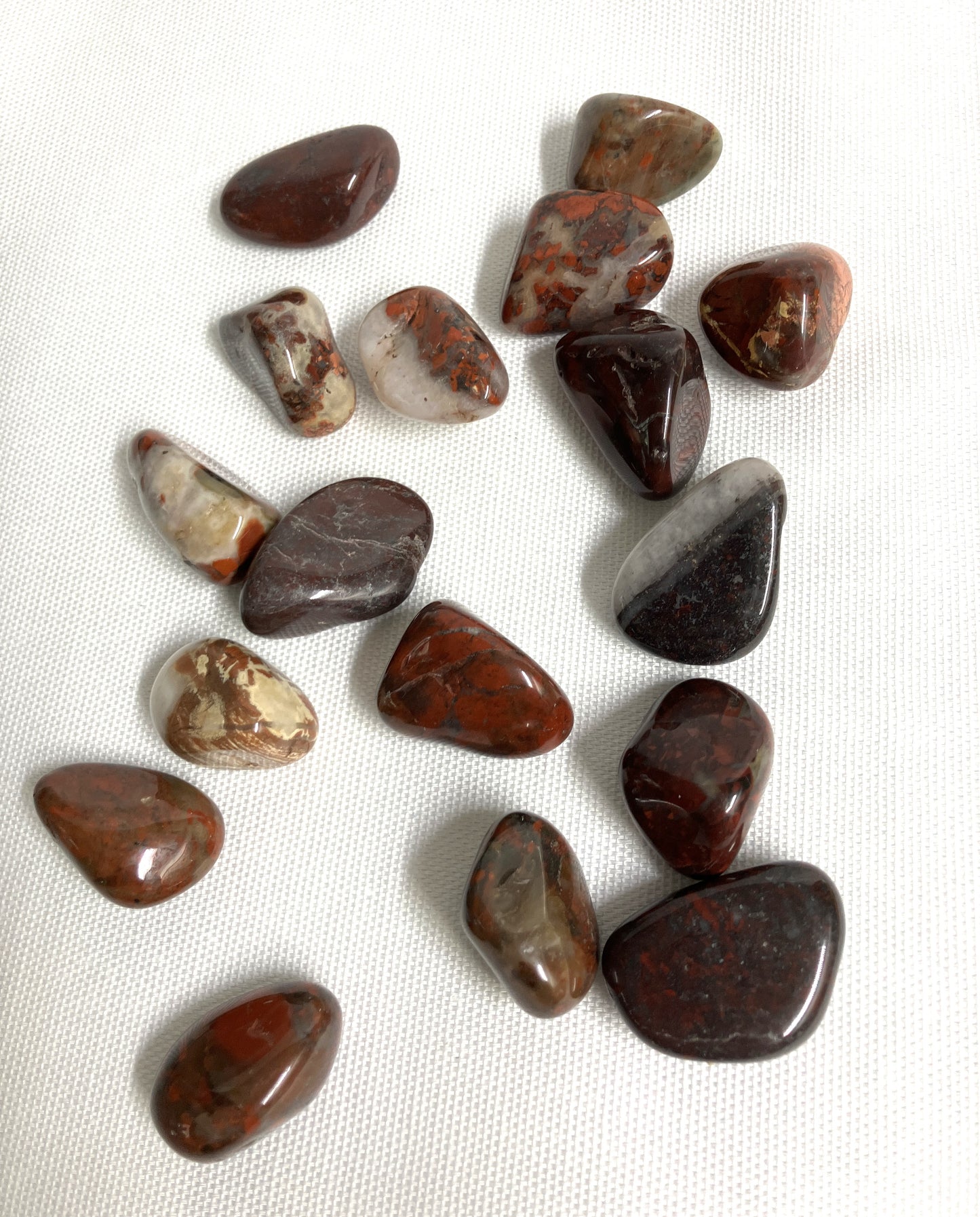 Brecciated Jasper Crystal showing different patterns on a white fabric background