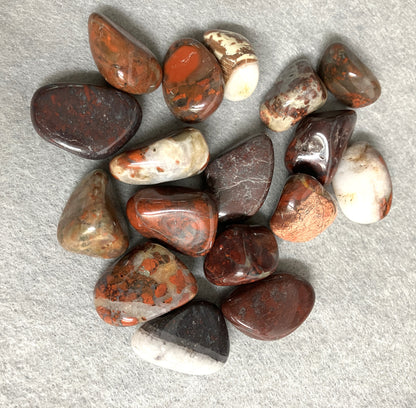 Collection Tumbled Brecciated Jasper Crystals  on a gray surface