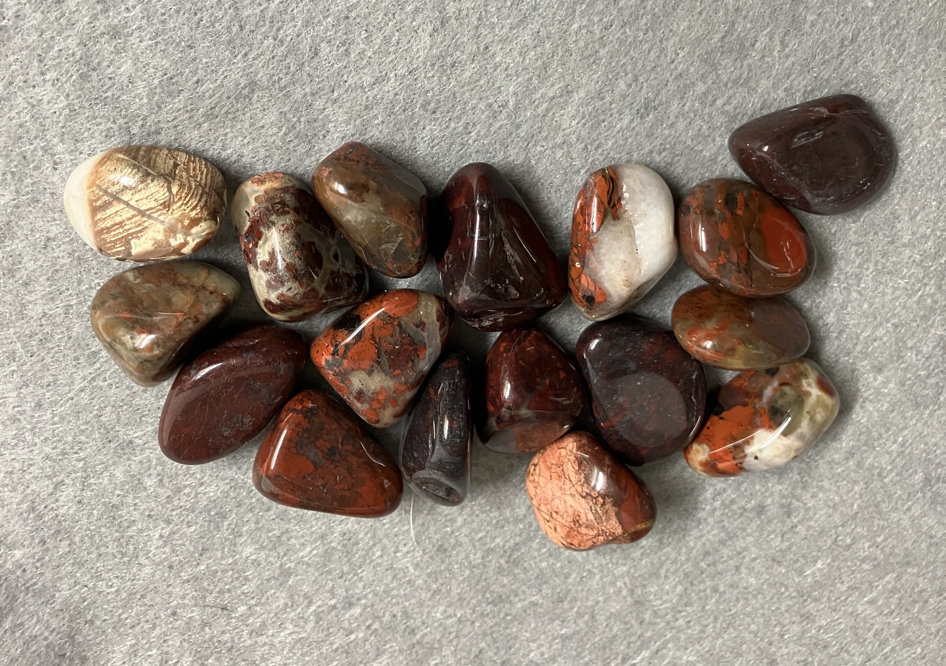 Assorted Brecciated Jasper Crystal showing the variations of patterns on a gray surface