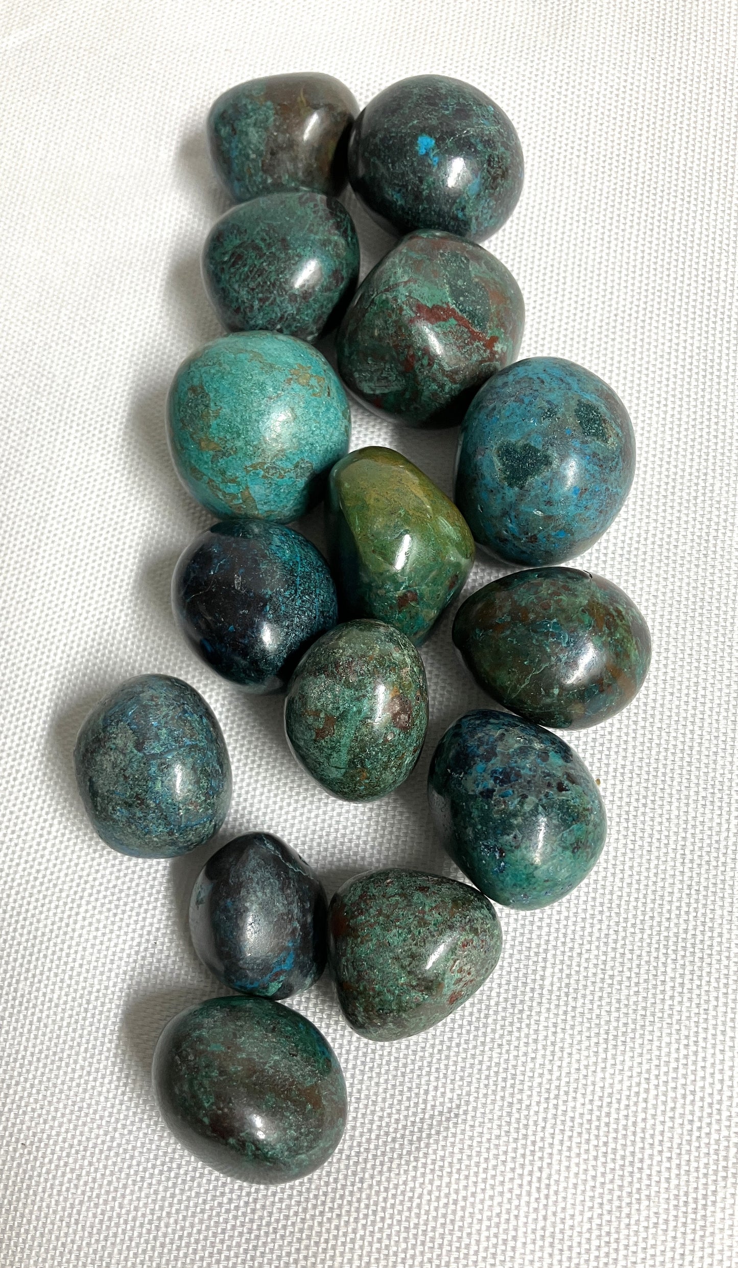 Assorted Chrysocolla Crystals on a white fabric background