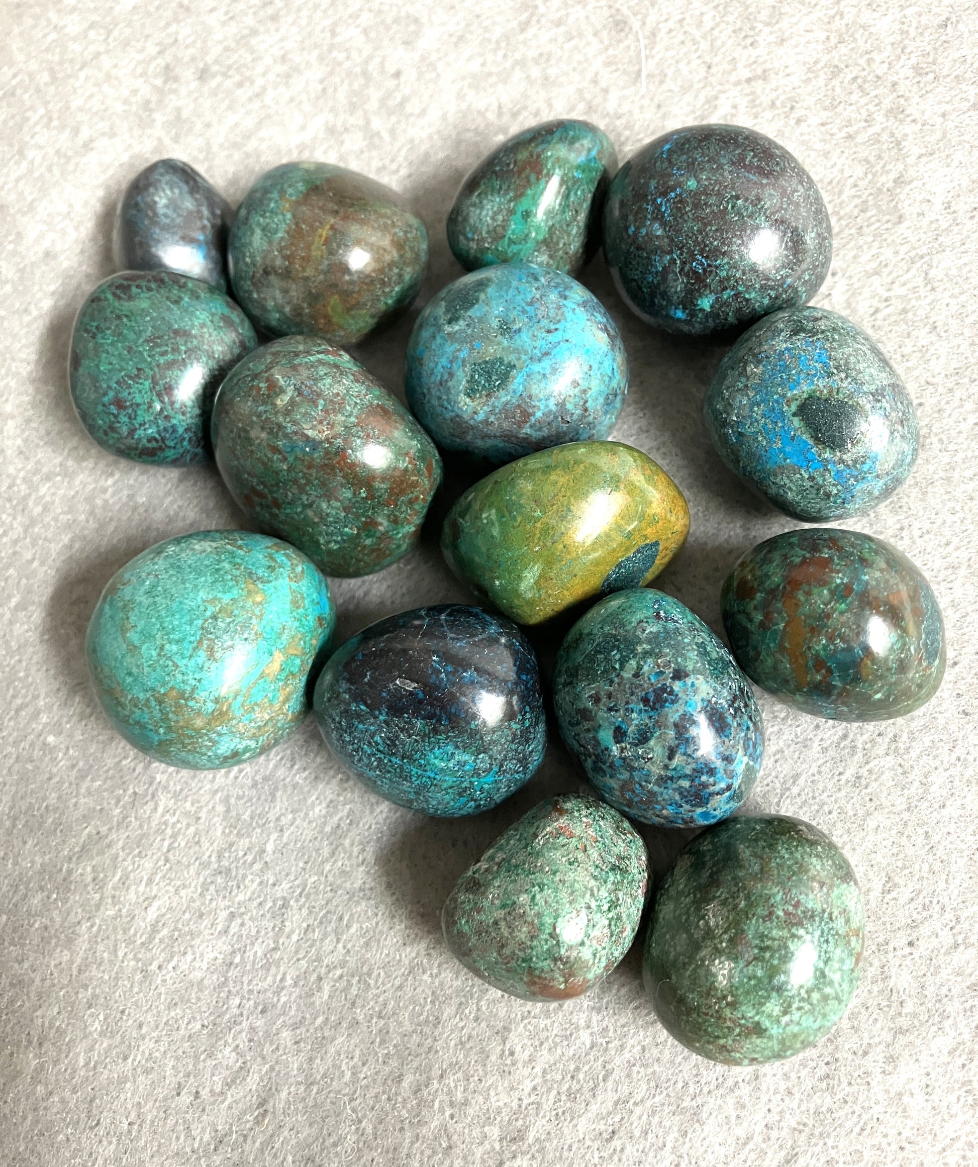 Chrysocolla Crystal displaying the spectacular colors and patterns on a light gray background