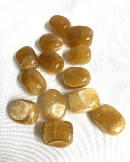 Group of Honey Caramel Calcite Crystals showing the assorted colors on a white background