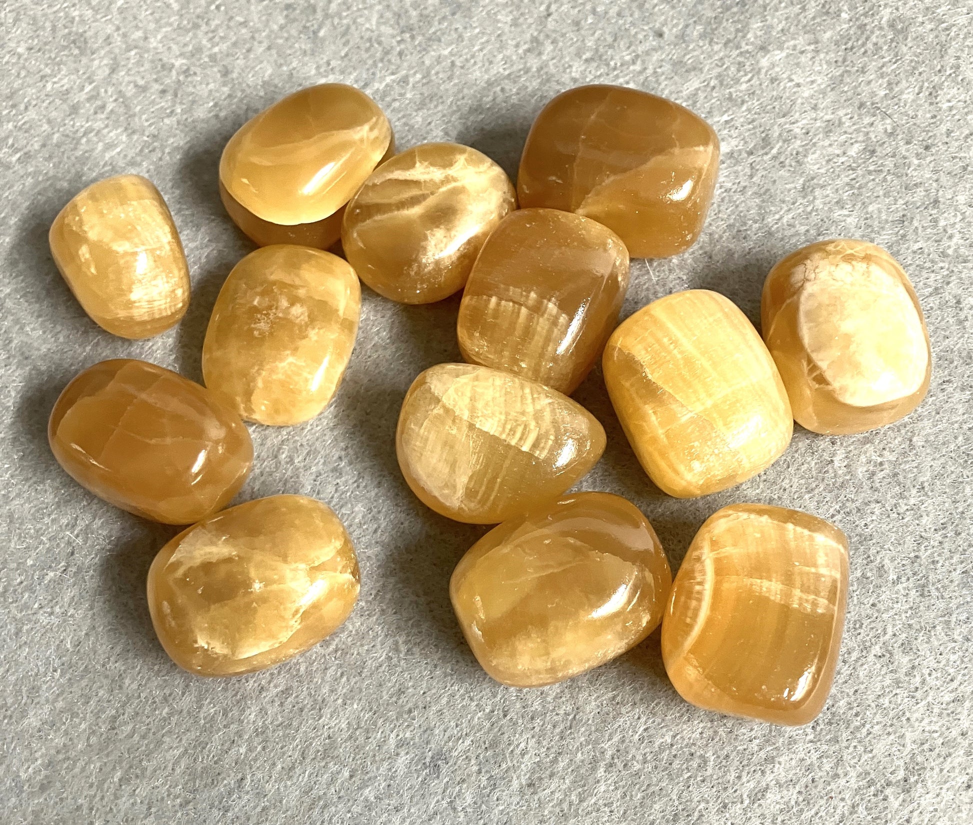 front view of Honey Caramel Calcite Crystals on a gray surface