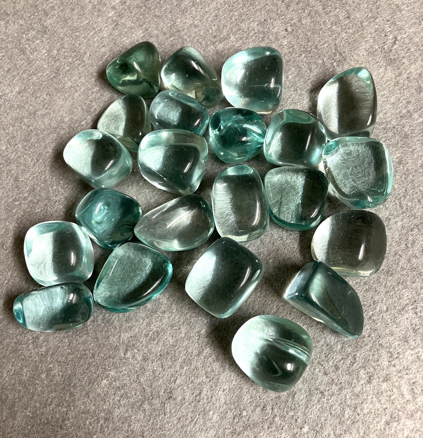 Blue Obsidian Crystal shown with the front up on a gray surface