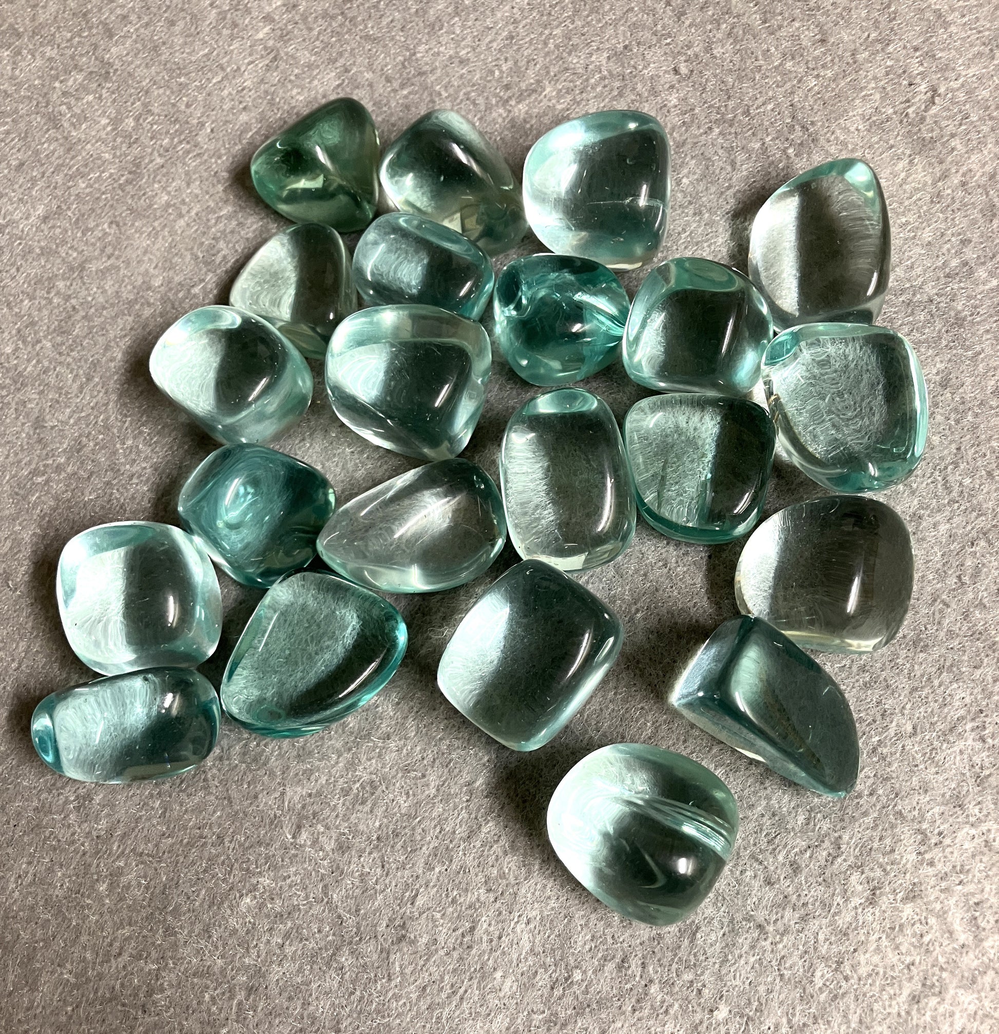 Blue Obsidian Crystal shown with the front up on a gray surface