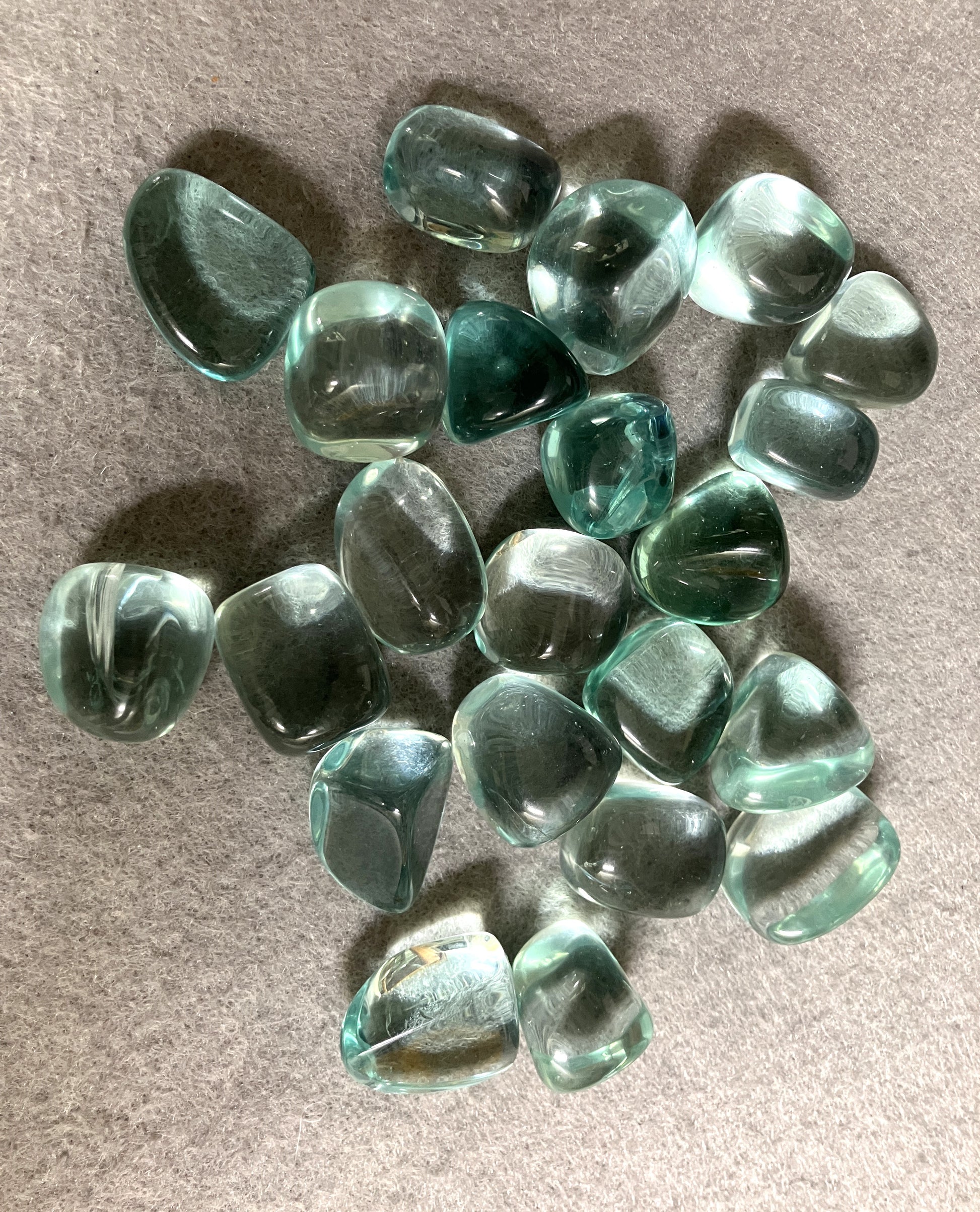 Collection of Blue Obsidian Crystal gemstones on a gray surface