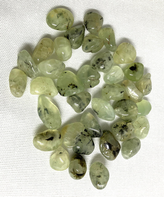 Prehnite with Epidote Crystals in a group shown on a white fabric background