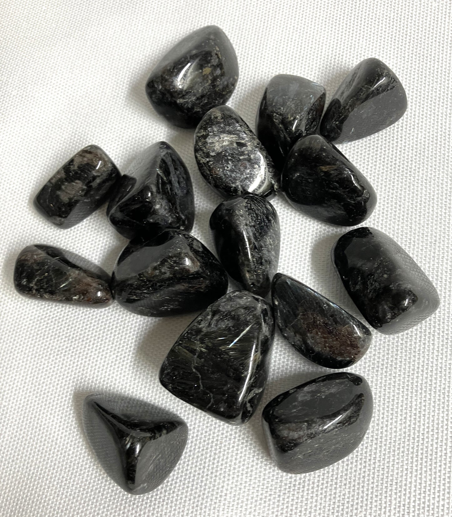 Another grouping of Astrophyllite Crystals  on a white fabric background