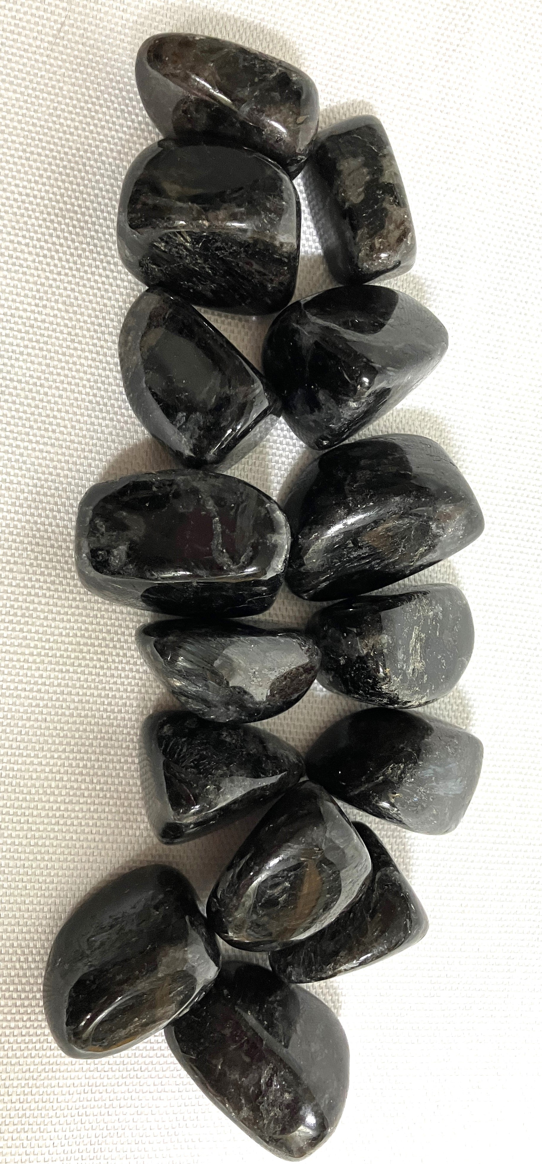 Showing Astrophyllite Crystals from the front on a white fabric background