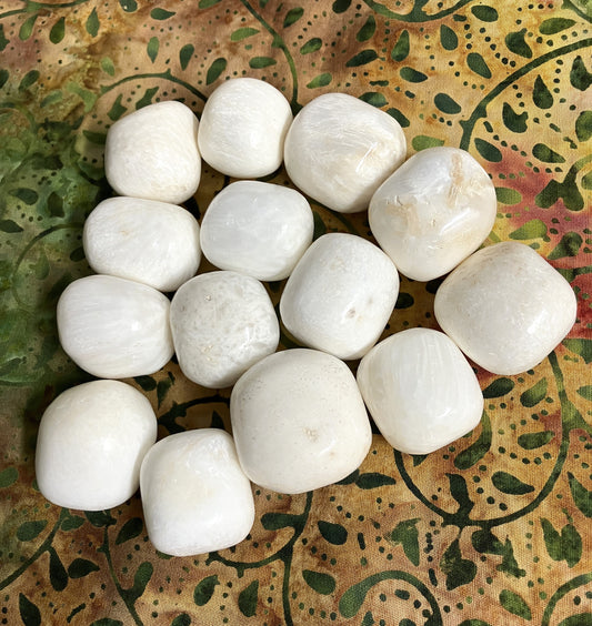 Scolecite Crystals arranged in a circular pattern on a decorative fabric background