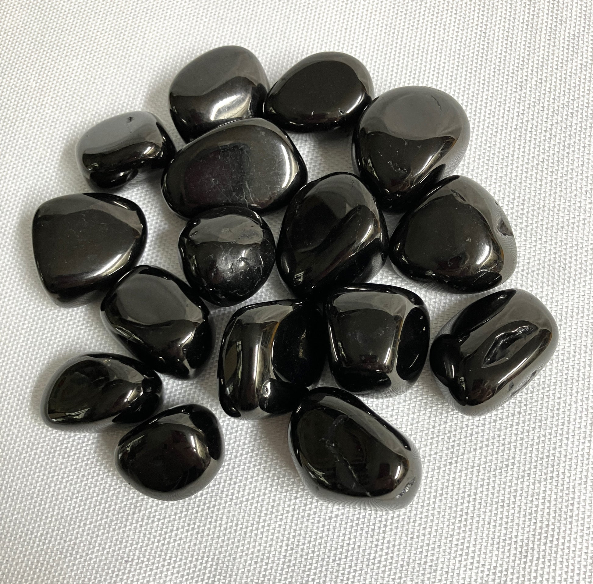 Showing an assortment of Jet Crystals on a white fabric background