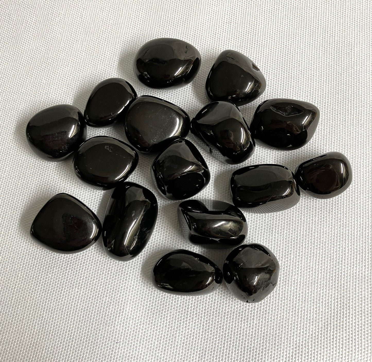 Tumbled Jet Crystals on a white fabric background