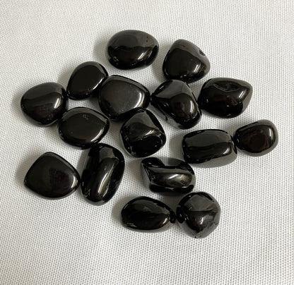 Tumbled Jet Crystals on a white fabric background