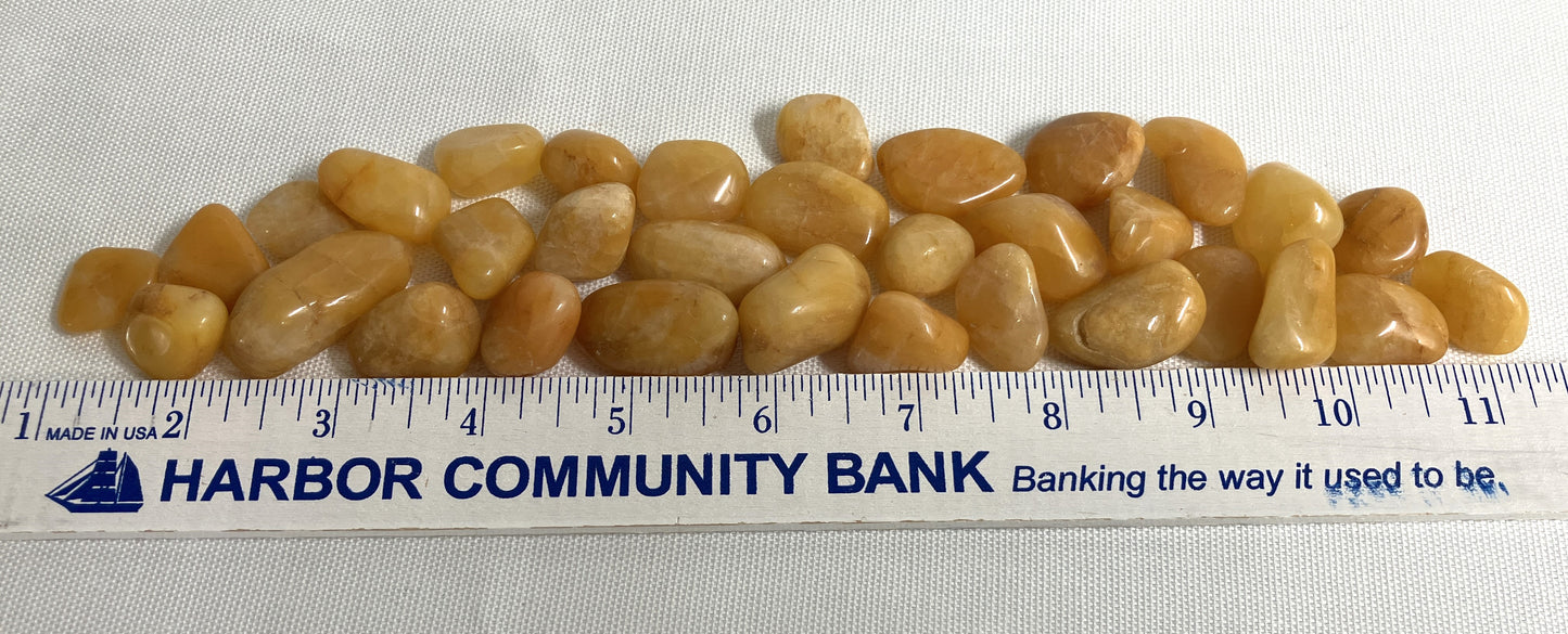 Apricot Quartz Crystals on a white background with a ruler for scale