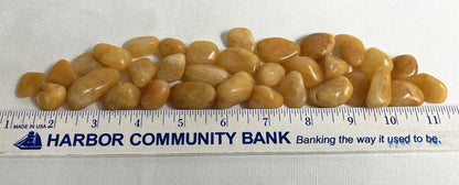 Apricot Quartz Crystals on a white background with a ruler for scale
