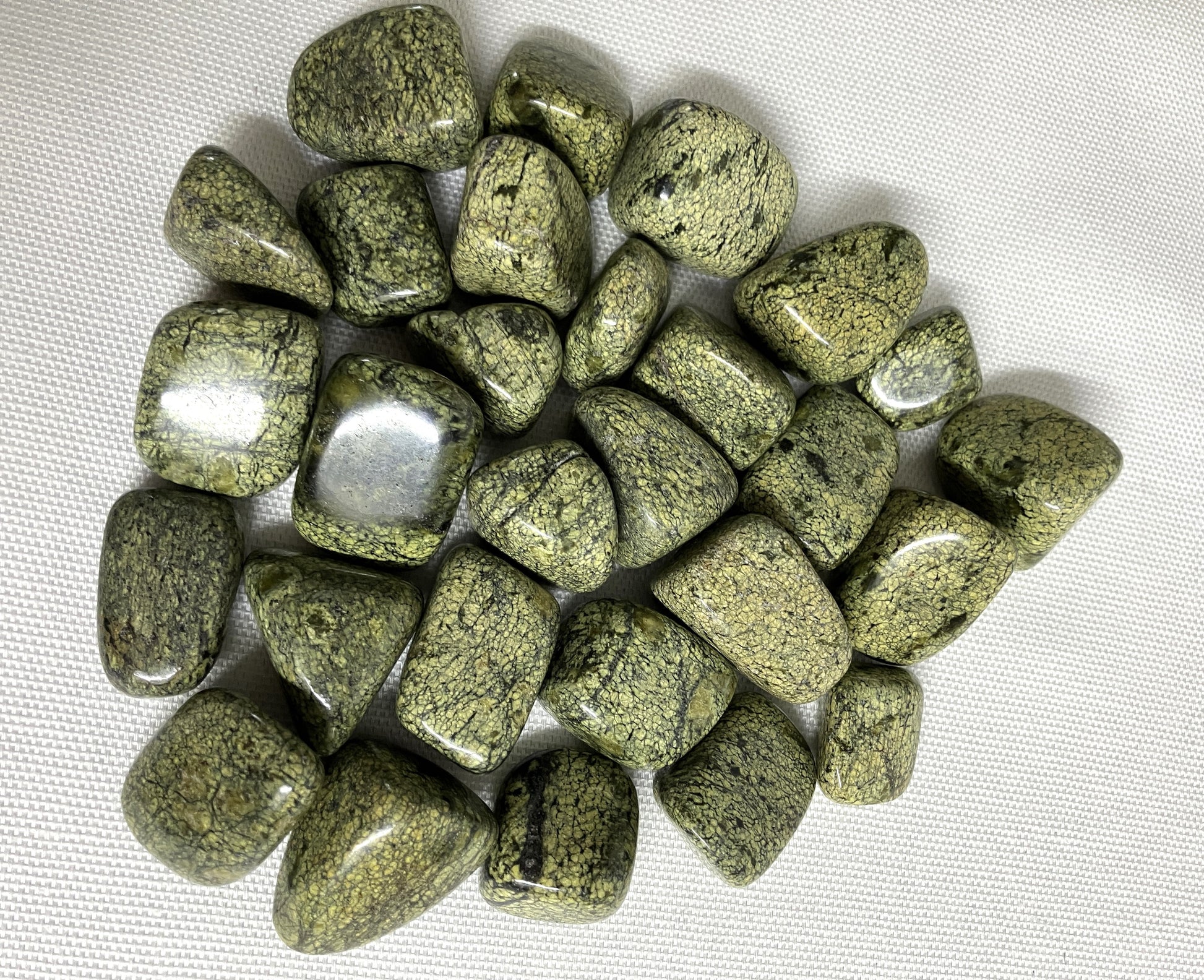 Back view of Asterite Serpentine Crystals on a white fabric background