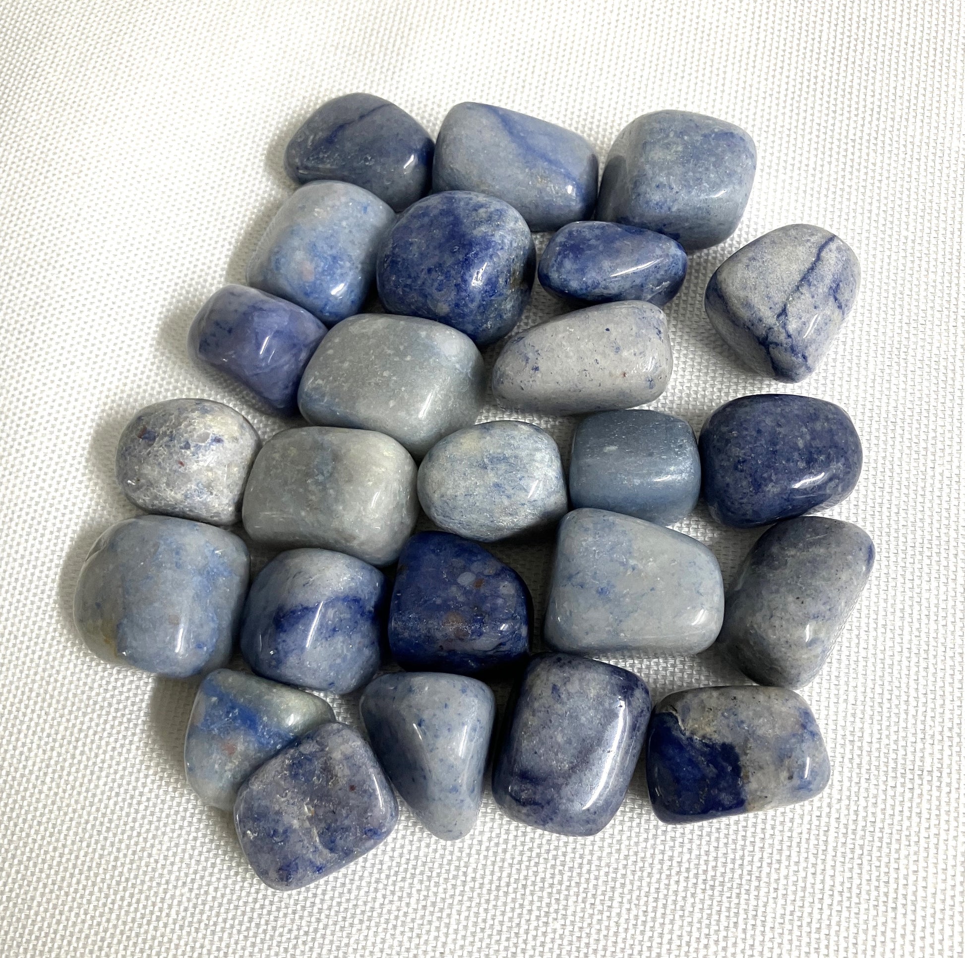Closeup of Tumbled Dumortierite Crystals on a white fabric background