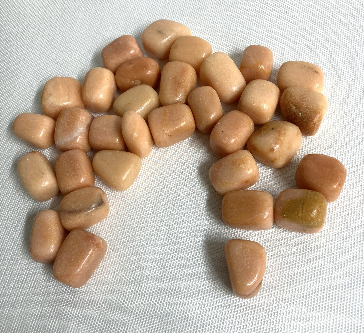 Bottom side view of Peach Calcite Crystals on a light fabric background