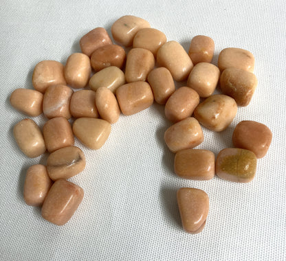 Bottom side view of Peach Calcite Crystals on a light fabric background