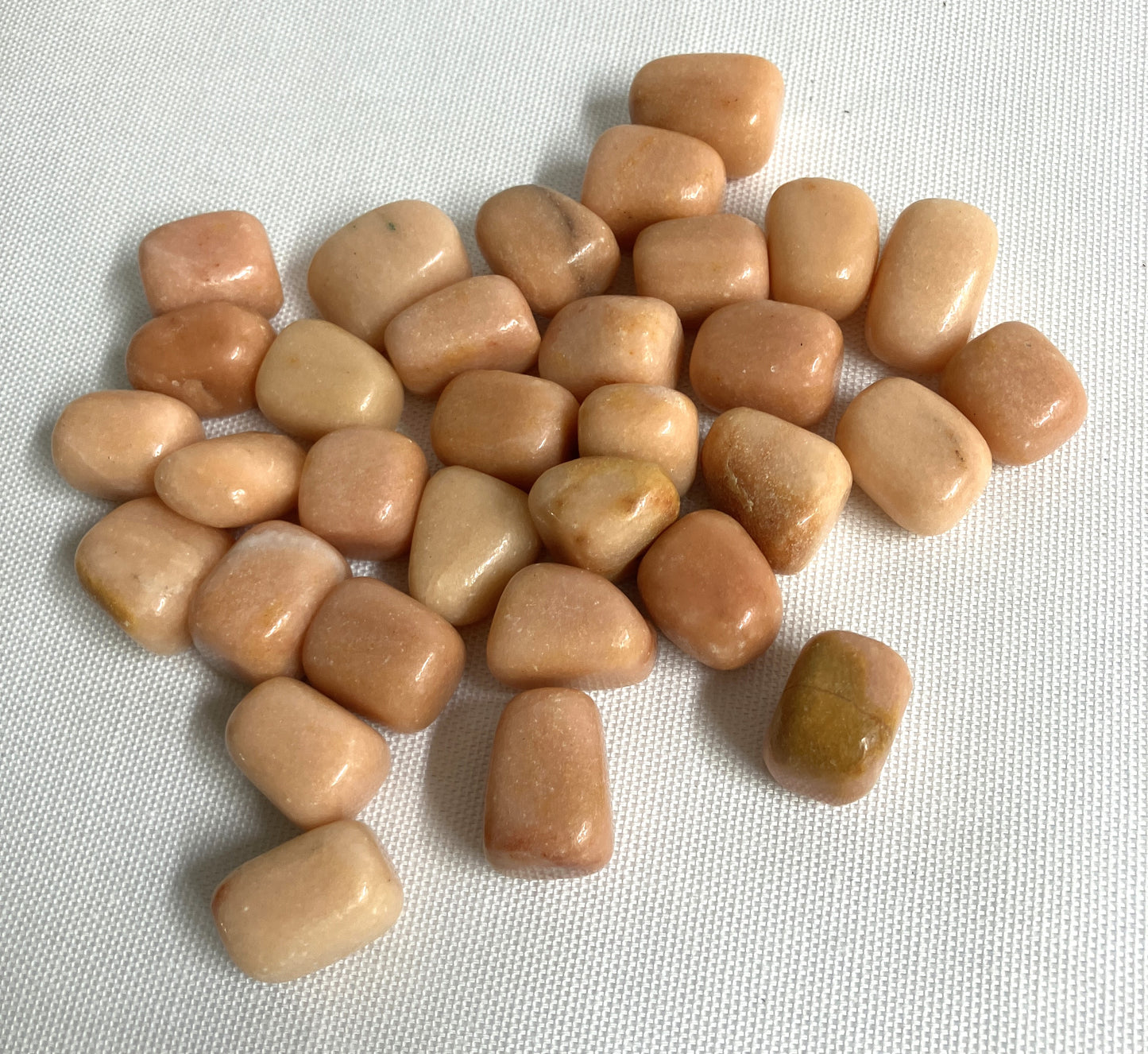 Top view of Peach Calcite Crystals on a light fabric background