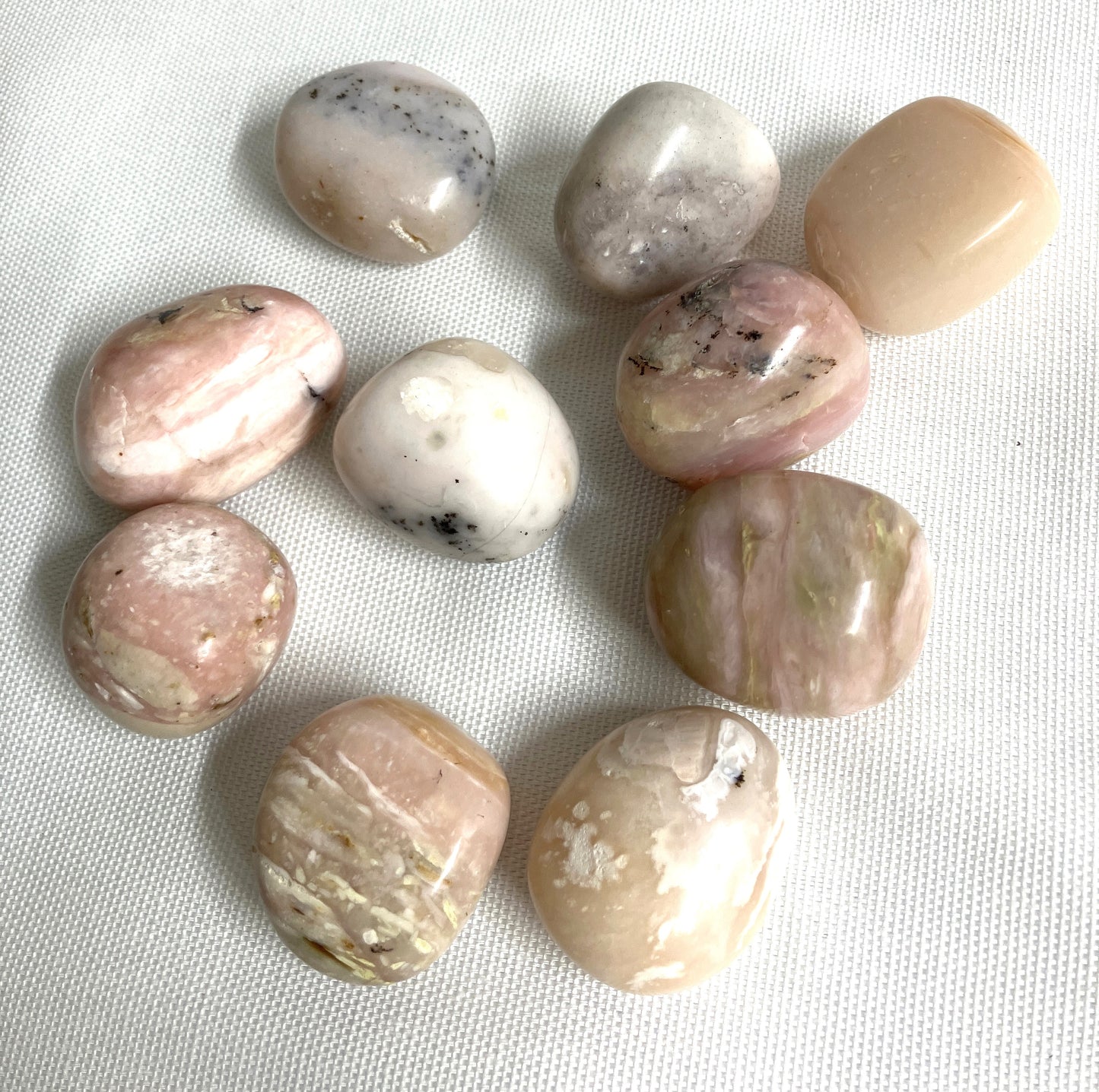 Grid of Pink Opal Crystals on a white fabric background