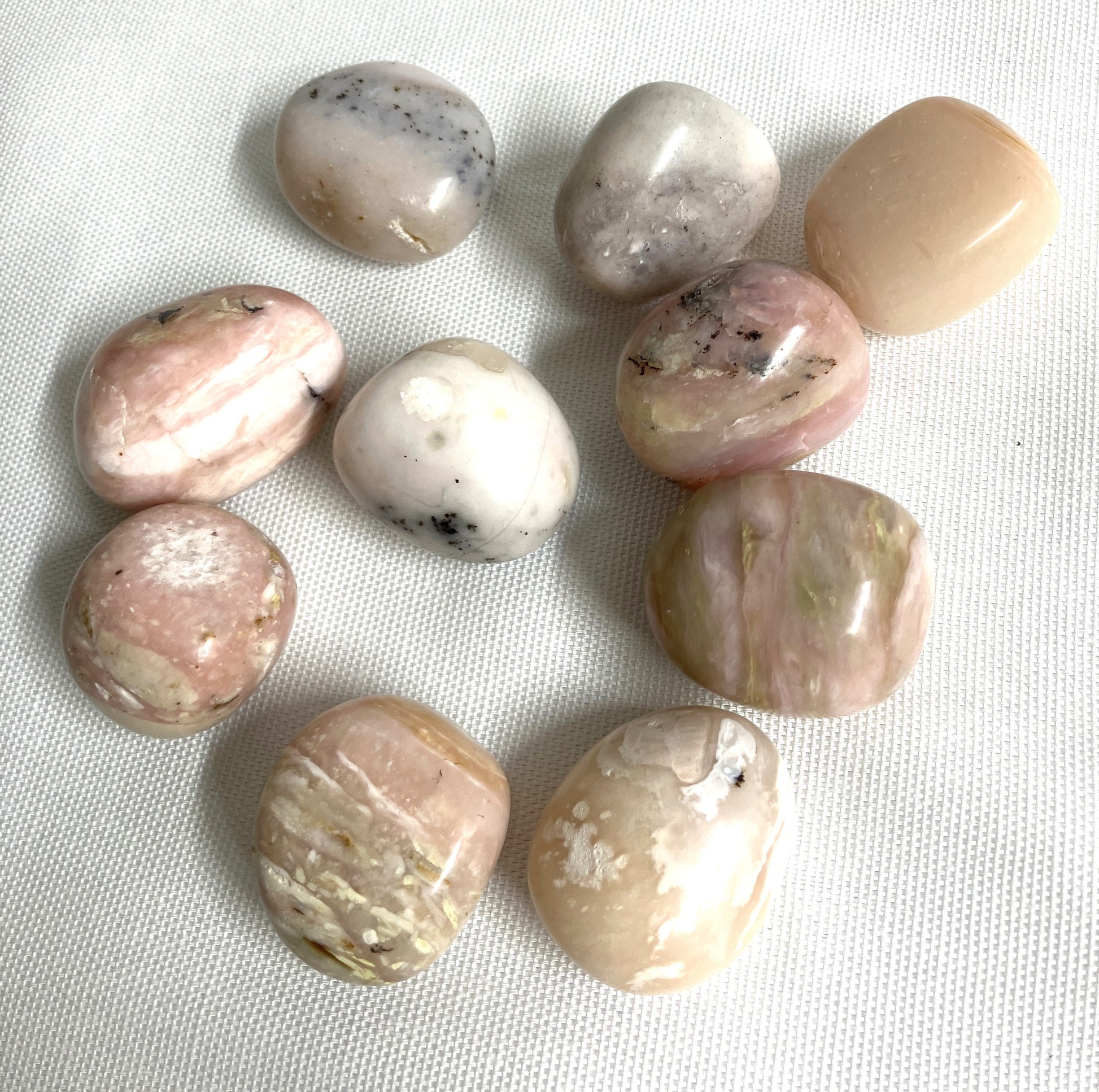 Grid of Pink Opal Crystals on a white fabric background