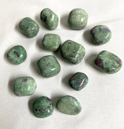 grouping of Ruby Fuchsite Crystals on a white fabric background