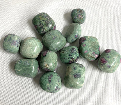 Assorted Ruby Fuchsite Crystals on a white fabric background
