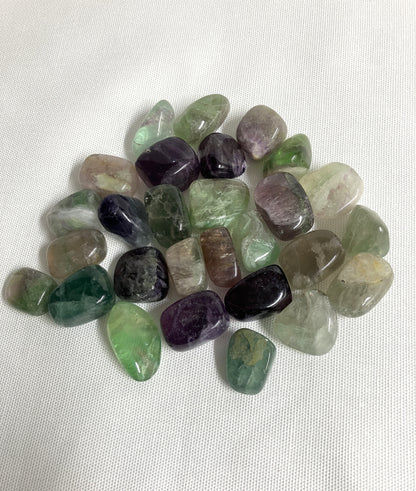 Assorted Fluorite Crystals showing color and size on a white fabric background