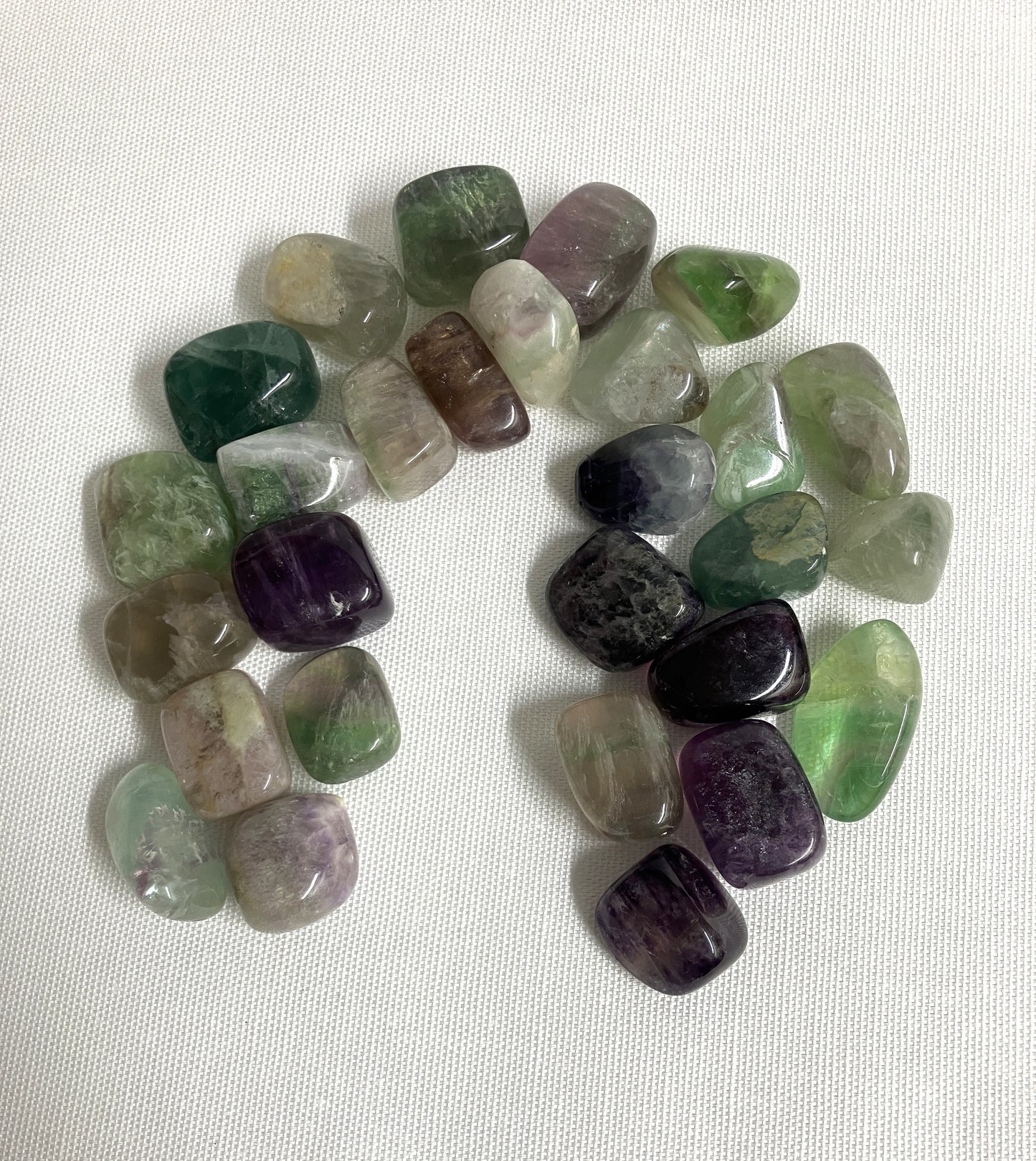 Assorted Fluorite Crystals showing the front view on a white fabric background