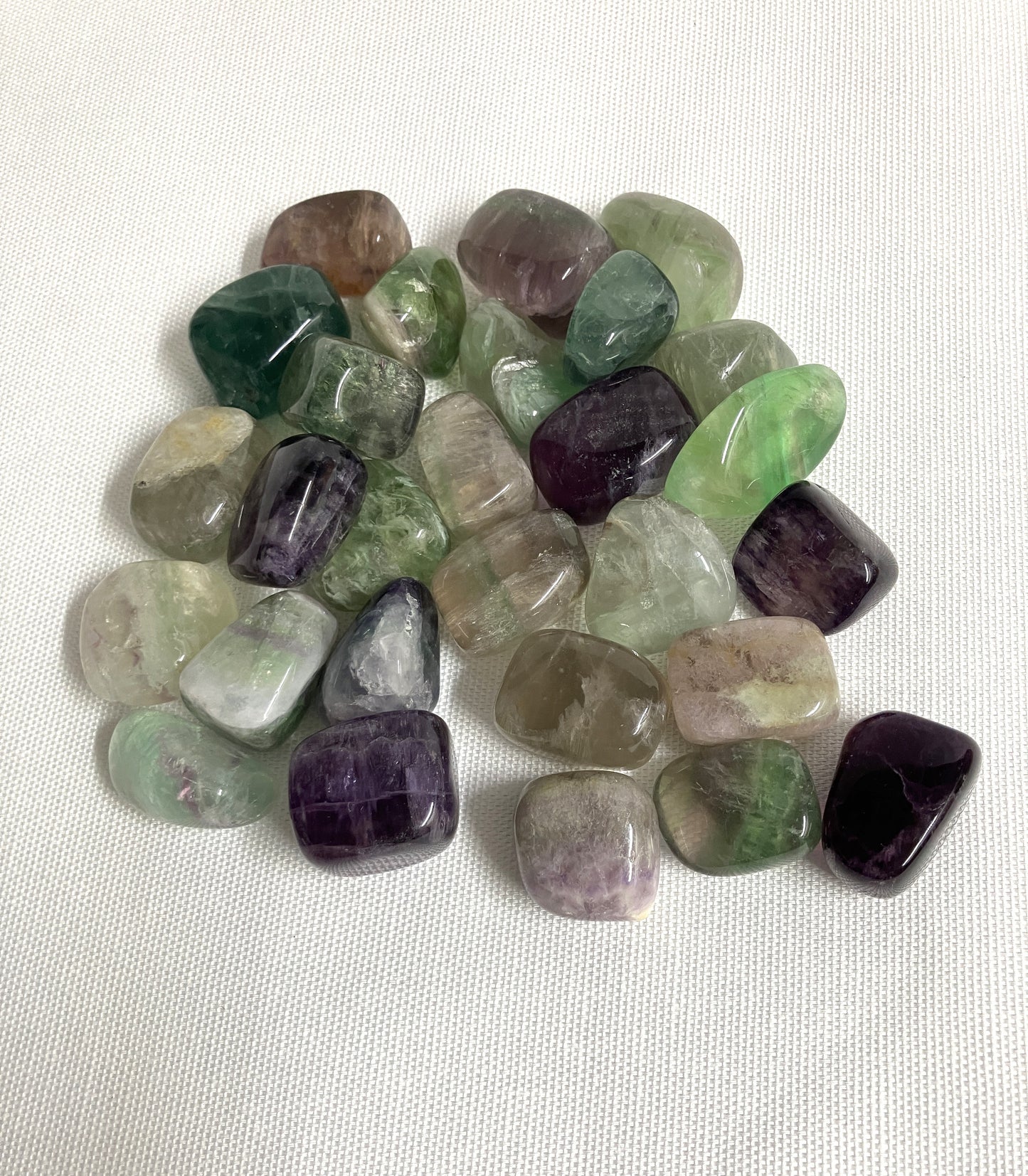 Assorted tumbled Fluorite Crystals on a white background