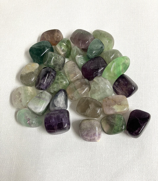 Assorted tumbled Fluorite Crystals on a white background