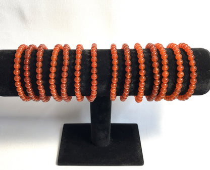 Carnelian Beaded Stretch Bracelets on a black stand against a white background