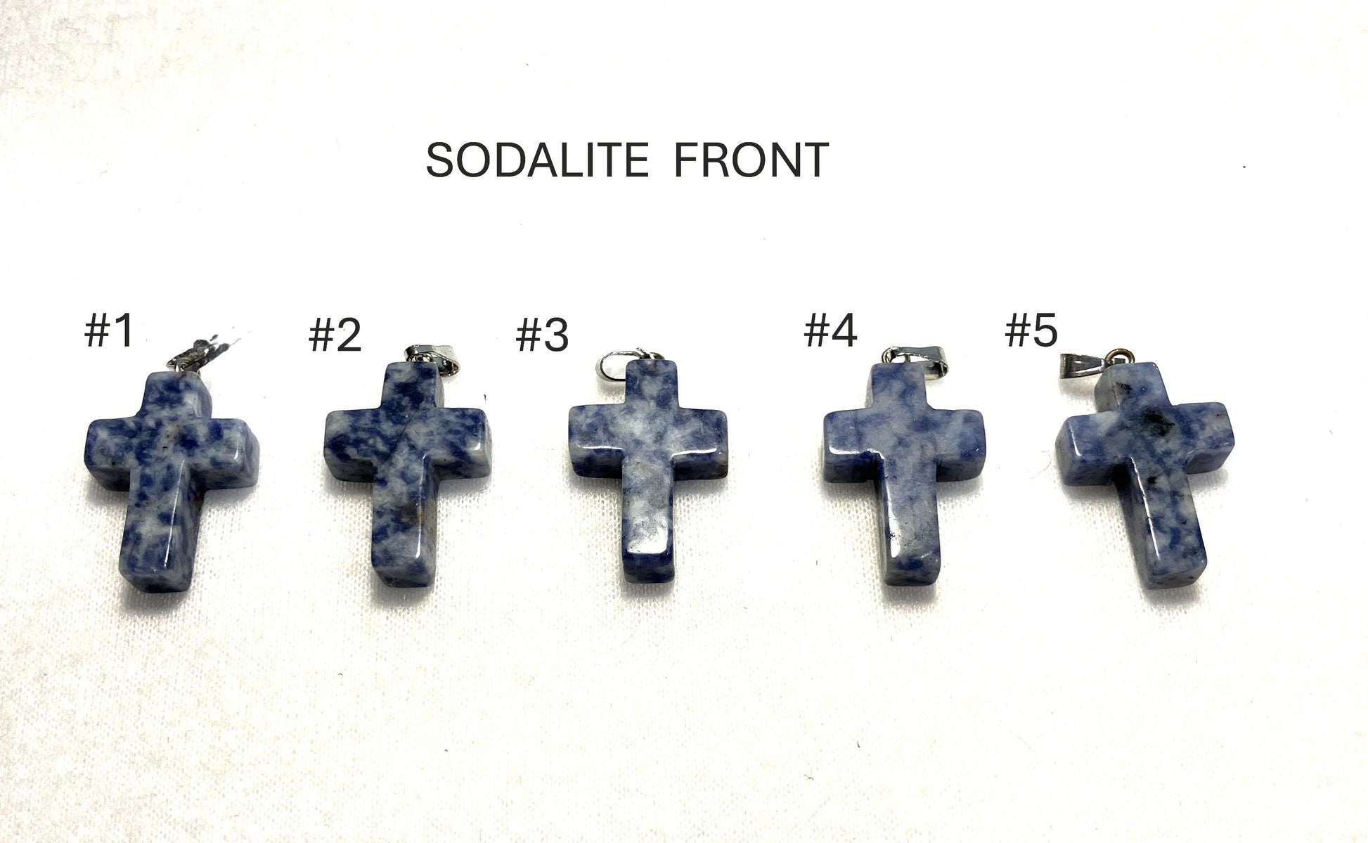 Front view of five sodalite cross pendants labeled #1 to #5 on a white background.