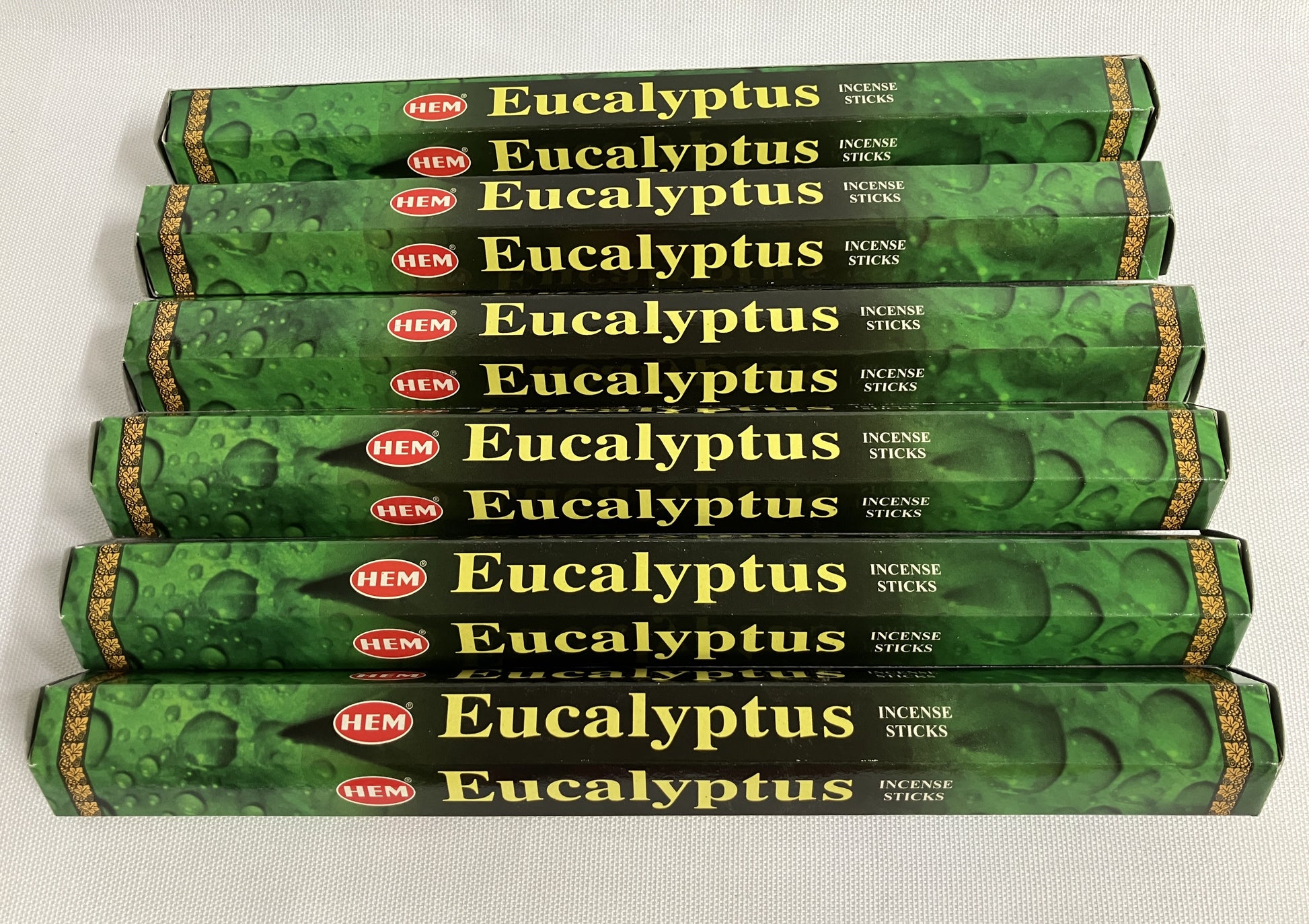 Multiple boxes of HEM Eucalyptus incense sticks on a white background