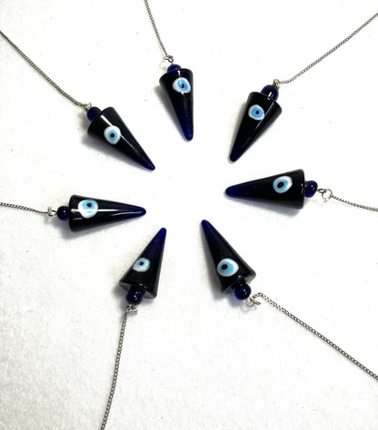 Cobalt Blue Evil Eye Pendulums with light blue eyes on white iris against a white background arranged in a circle