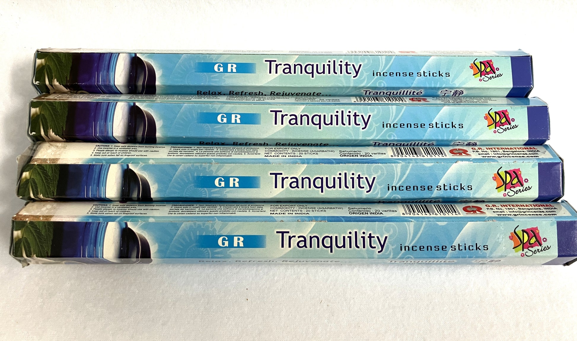 Four packages of  G R Tranquility incense sticks on a white background