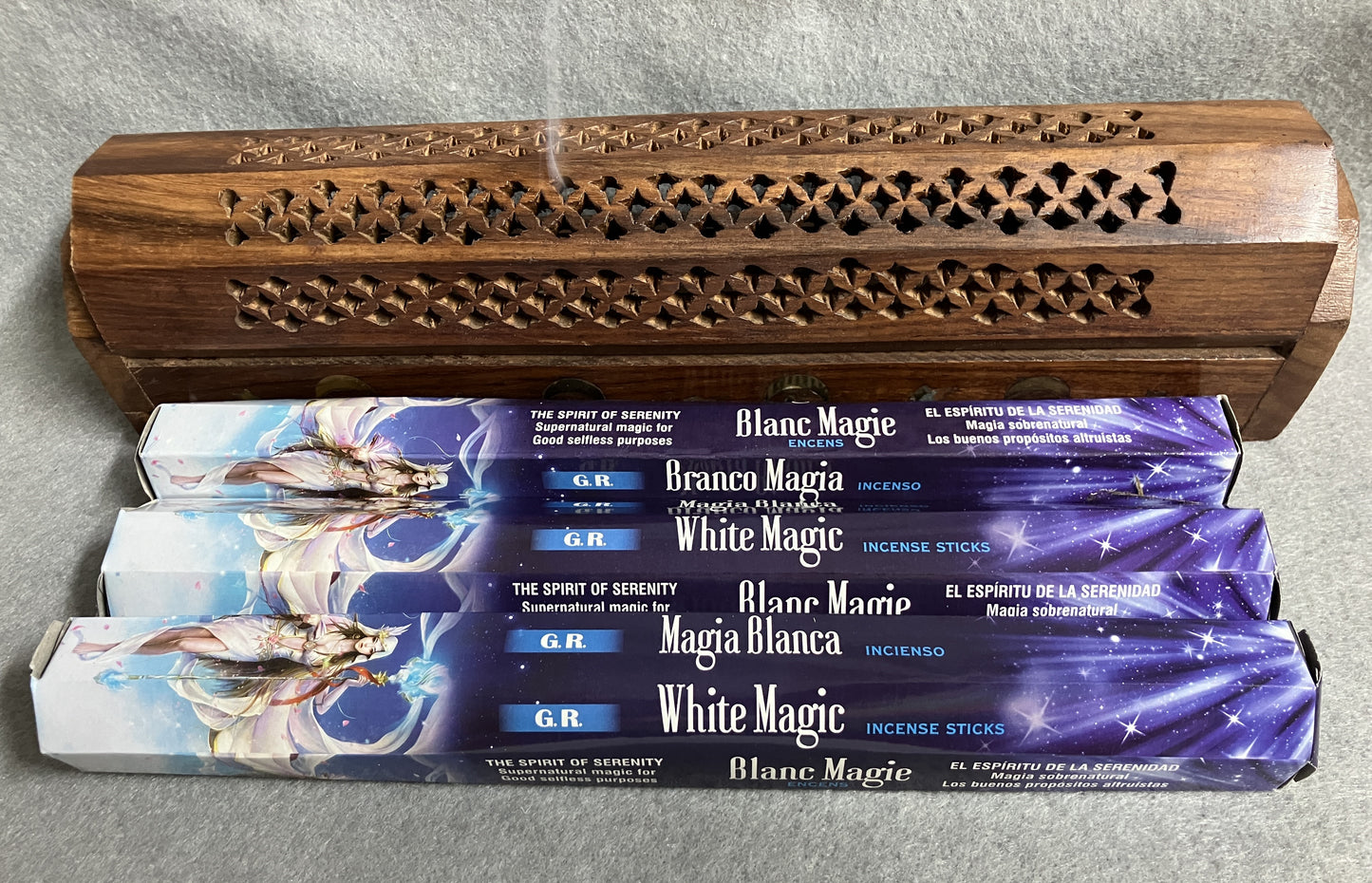 White Magic incense  boxes of 20 sticks with a wooden incense burner in the background.