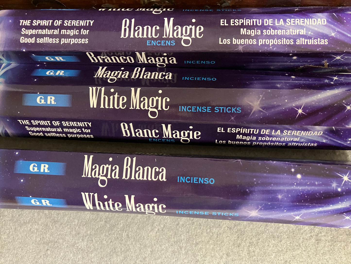 Stack of 'Blanc Magie' and 'White Magic' incense stick packages on a gray surface.