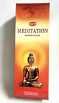 Box of HEM Meditation incense sticks with a Buddha statue on an orange background